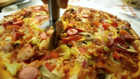 cutting a deliciously topped pizza