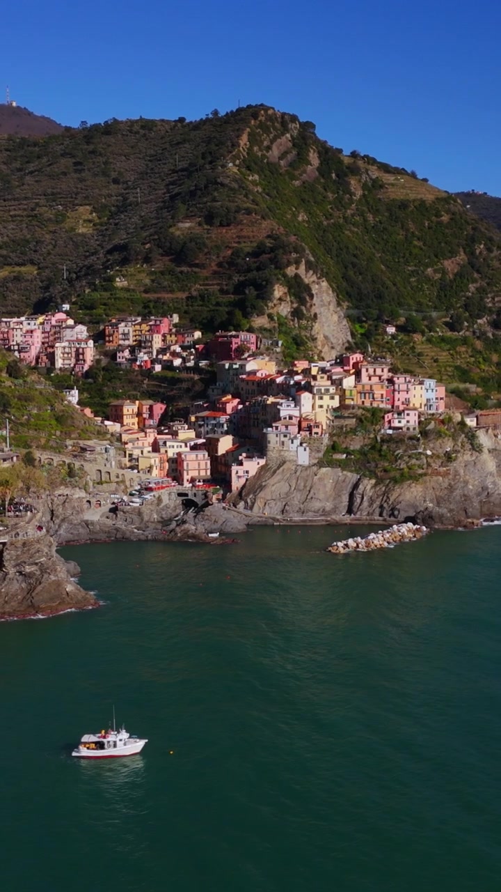 Vista aerea verticale del villaggio di Manarola con una barca che attraversa il Mar Ligure.