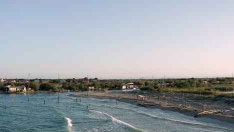 Aerial-view-of-fishing-huts-with-typical-italian-fishing-machine,-called-"trabucco",Lido-di-Dante,-fiumi-uniti-Ravenna-near-Comacchio-valley