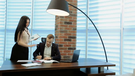 businessman placing the signature. businesswoman presenting a document to her boss for his signature