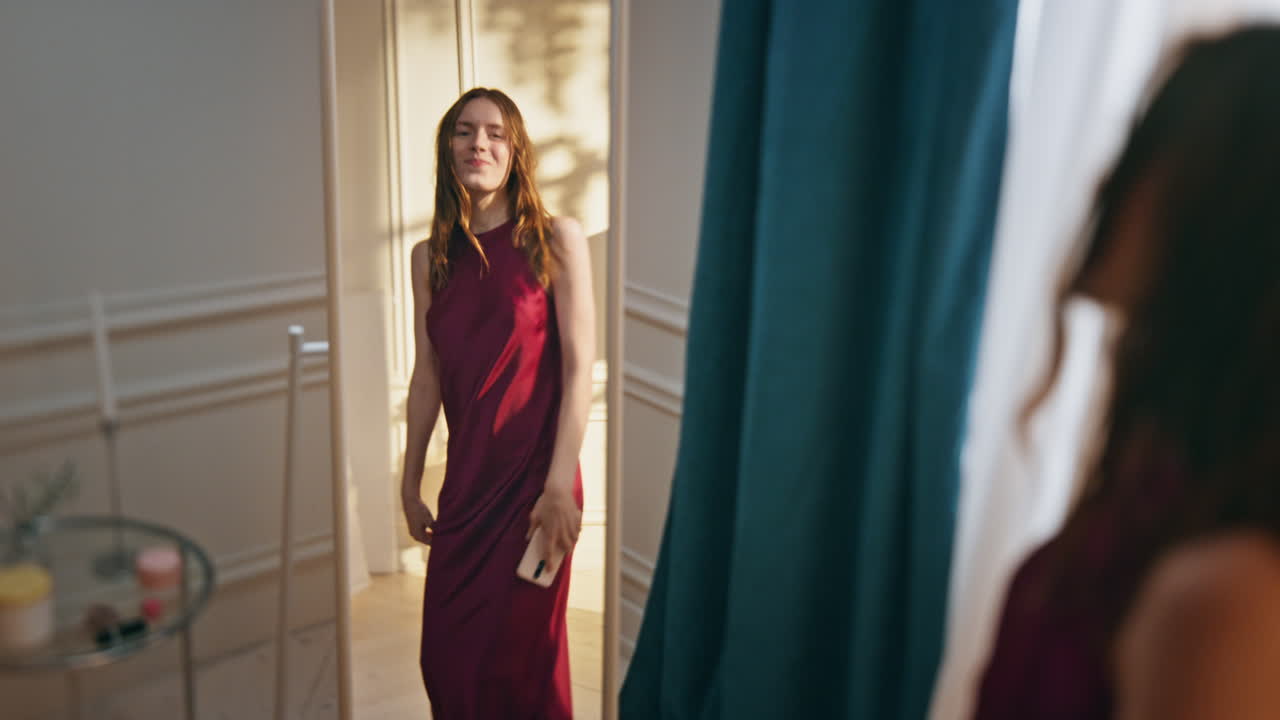 웃는 소녀가 저녁 데이트를 준비하고 있습니다. 행복한 여자가 거울을 보려고합니다.