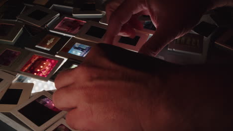 a photographer lines up colour slides on a backlit table