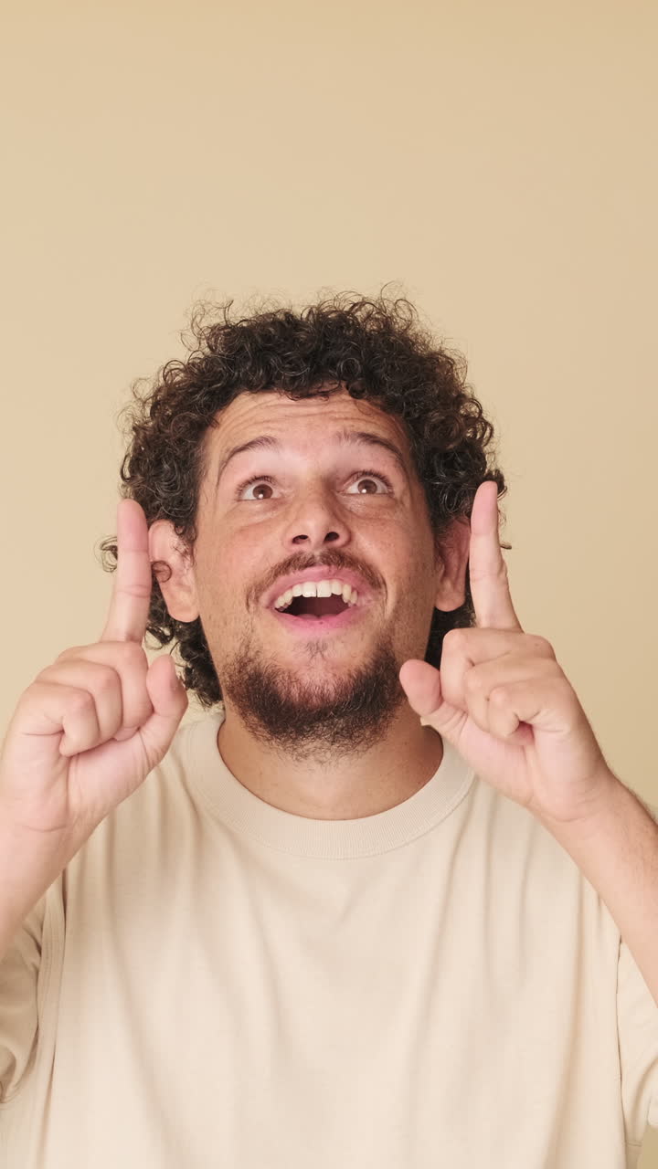 Uomo curioso guarda in alto e indica con un'espressione felice