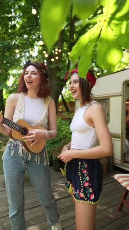 two friends playing ukulele outdoors