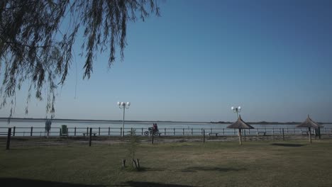 Static-slomo-shot-of-motorcycle-riding-on-Itati-beach-in-front-of-Parana-River