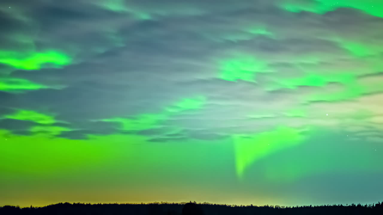 hermosa fotografía de las luces del norte en un cielo despejado con pocas nubes y estrellas fugaz en el cielo