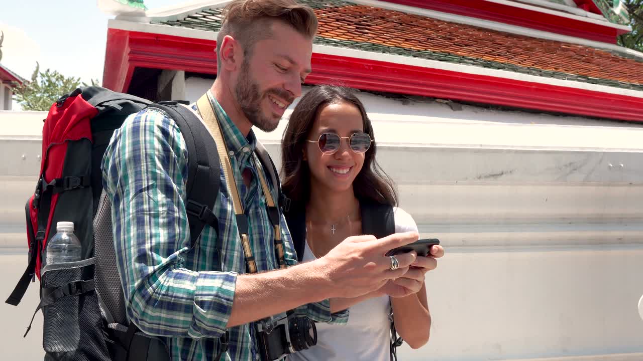 una pareja de turistas tomando una selfie con su teléfono inteligente en un templo tailandés en tailandia