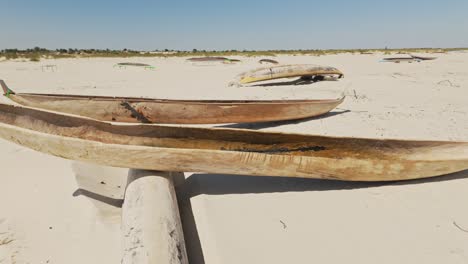 Piraguas-De-Madera-Tradicionales-Africanas-Hechas-A-Mano-En-Una-Playa-De-Arena-En-Un-Día-Soleado