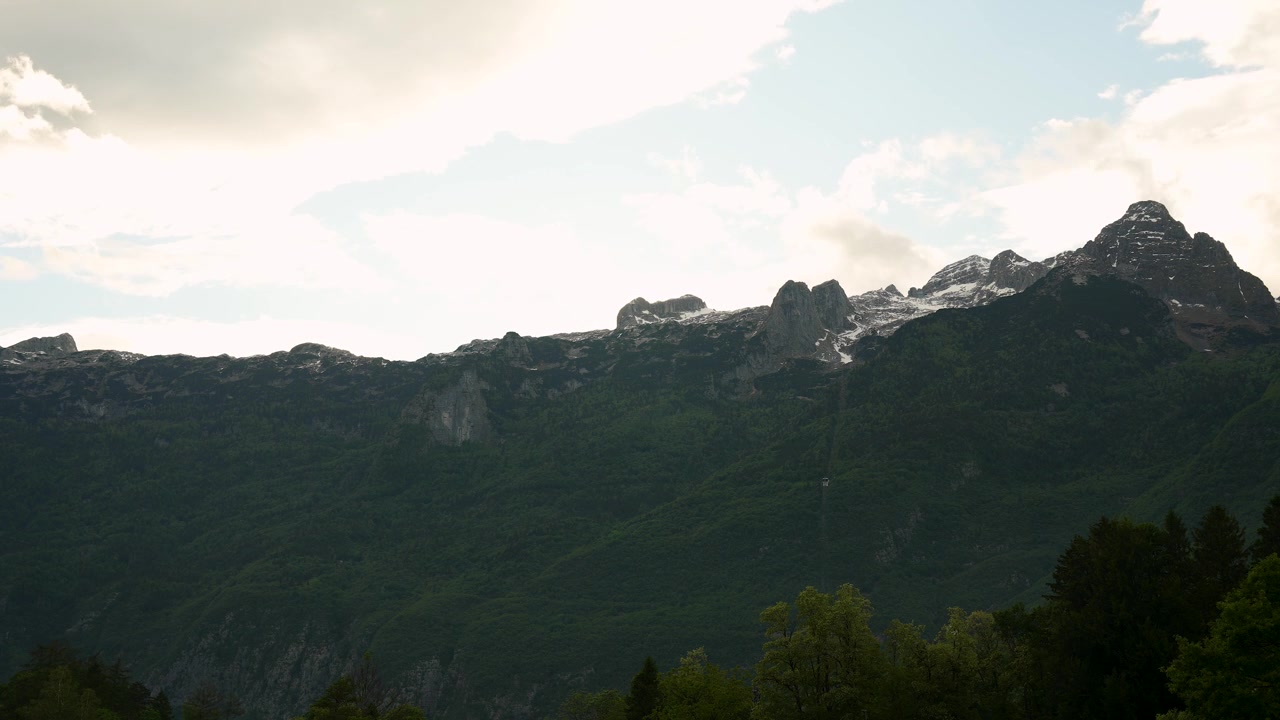 Timelapse del atardecer sobre las montañas Kanin en la frontera entre Eslovenia e Italia con nubes a la deriva, naturaleza alpina, clima, vida salvaje y vista del paisaje