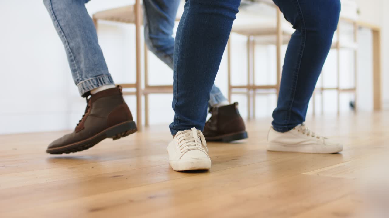 dance partners stepping backward trading cross-steps practicing footwork on wooden floor
