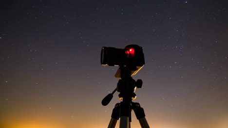 camera on a tripod under a starry night sky