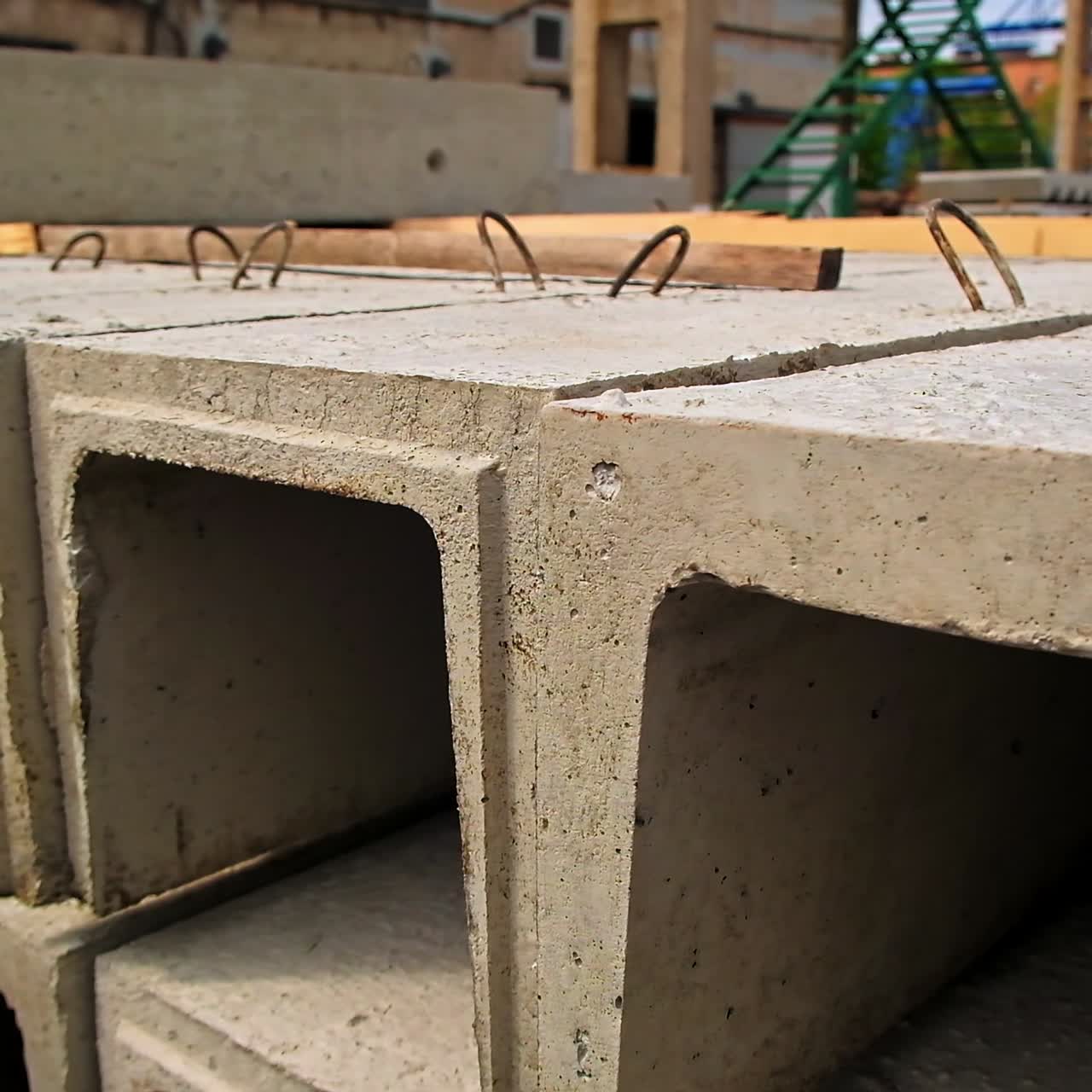 Arched armored concrete beams stacked outdoors. Close up. Industrial zone with building materials at backdrop