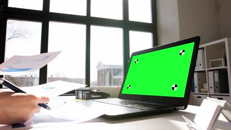 woman with laptop and charts works at home office