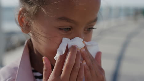 Cerrar-Una-Niña-Sonándose-La-Nariz-Con-Un-Pañuelo-De-Papel-Gripe-Infantil-De-Raza-Mixta-Joven-Al-Aire-Libre