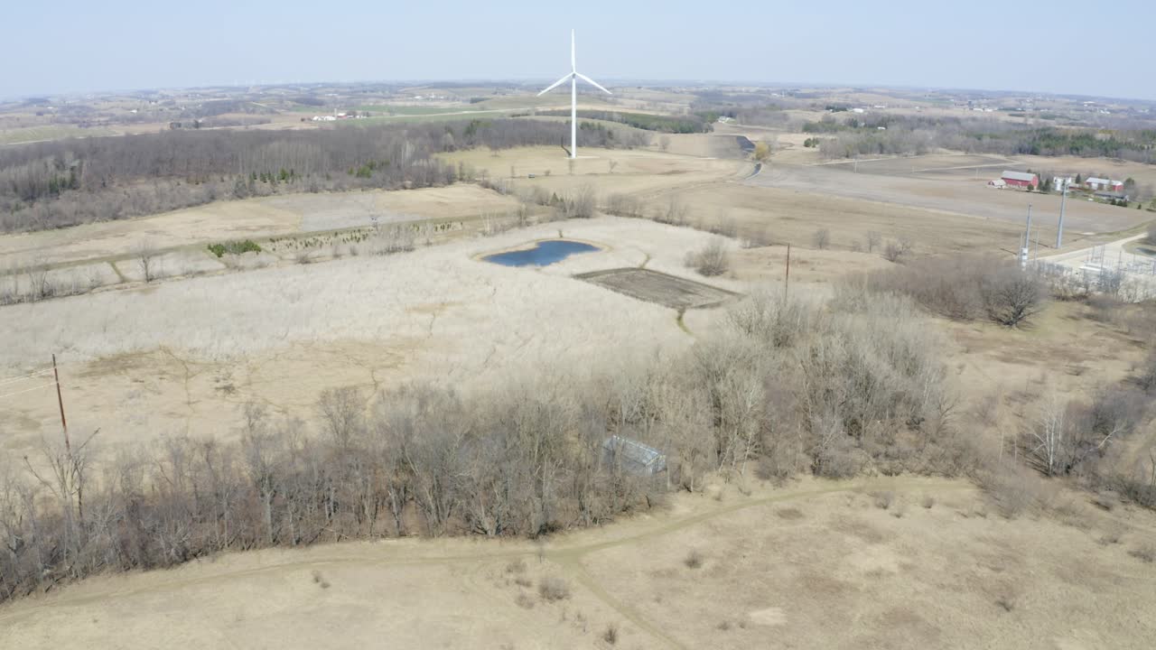 turbina eólica gigante girando lentamente en el campo rural a principios de la primavera