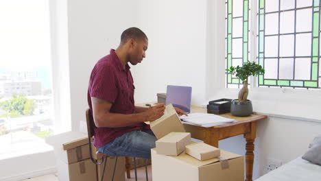 hombre que dirige un negocio desde casa enviando mercancías