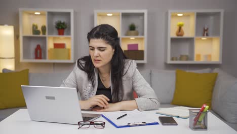 una mujer trabajadora de oficina en casa esperando nerviosamente en la computadora portátil.