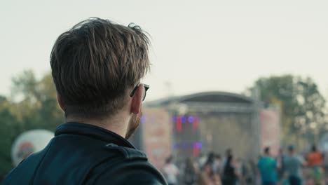 Vista-Trasera-De-Un-Joven-Caucásico-En-Un-Festival-De-Música-Mirando-El-Escenario.