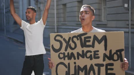 dos hombres de raza mixta en una marcha de protesta con pancartas levantando las manos y gritando