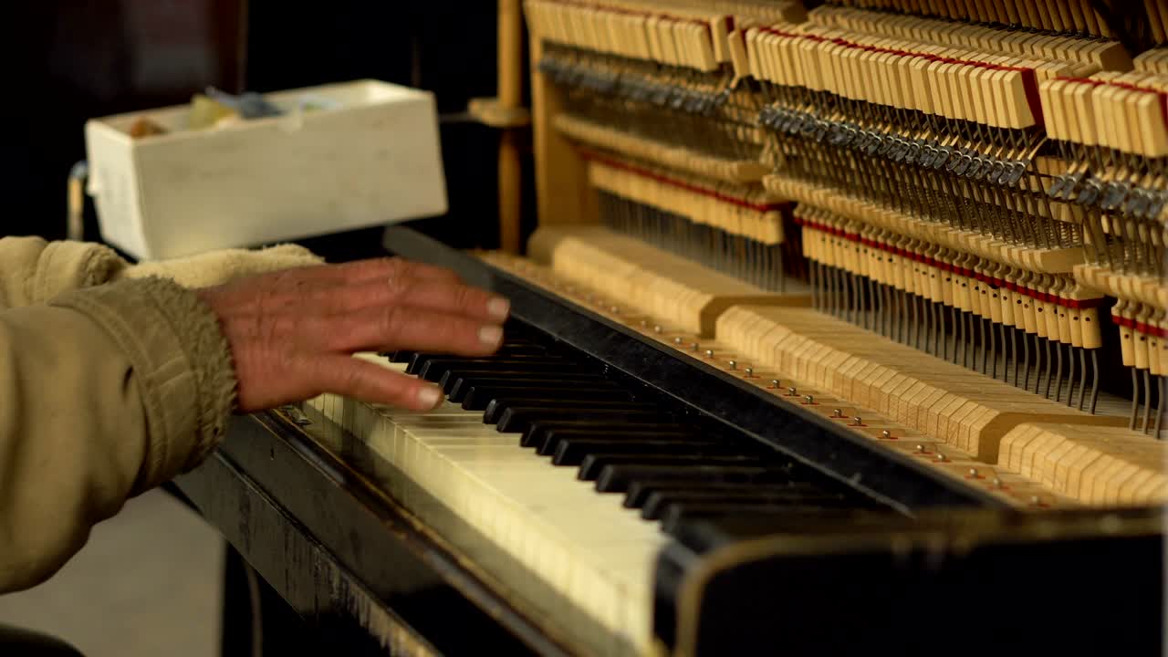 지하철 지하철에서 피아노를 연주하는 은이의 손은 열린 메커니즘과 줄과 망치를 가지고 있습니다.