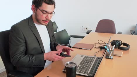 a man in a suit is typing on a laptop at a desk