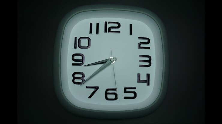 Time lapse white wall clock tells the time at 9o'clock.
