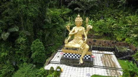 A-lesser-known-golden-Buddha-statue-located-in-East-Bali-in-the-jungle,-aerial