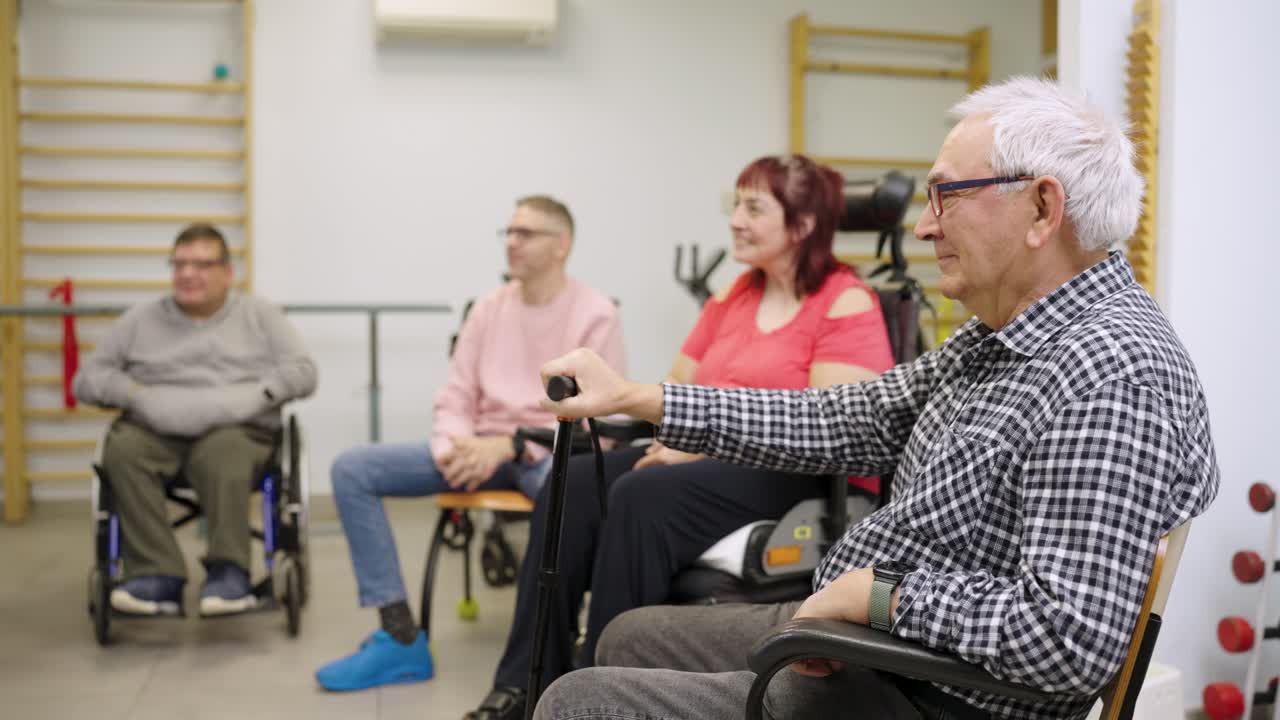 Seduta di terapia di gruppo con persone anziane in sedia a rotelle