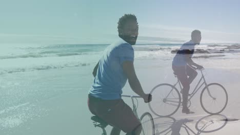 animation of african american man cycling over african american man cycling at beach