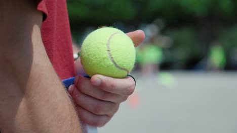 slow motion close-up shot of a person holding a tennis ball in their hand