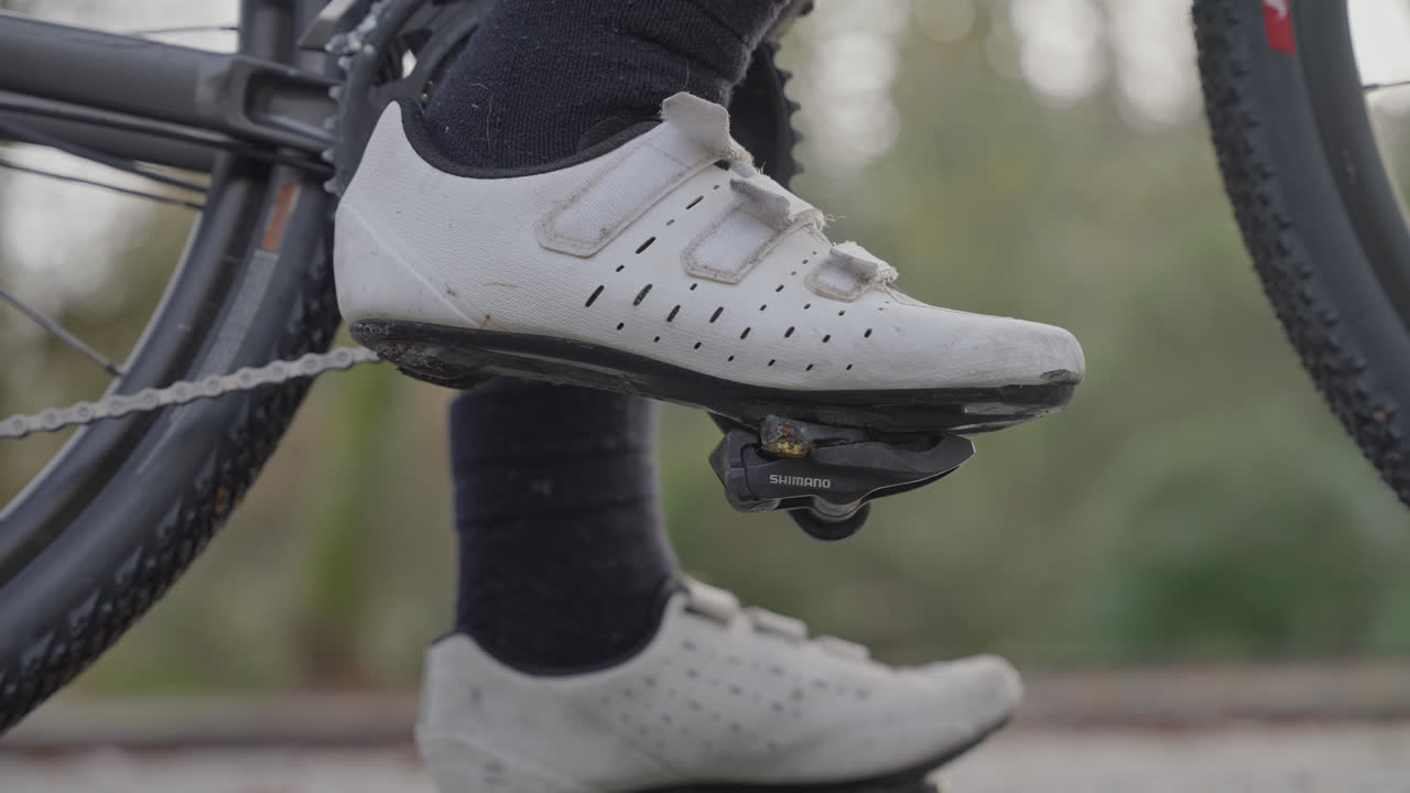 Scarpa da ciclista agganciata al pedale, con catena e pedivella, all'aperto di giorno