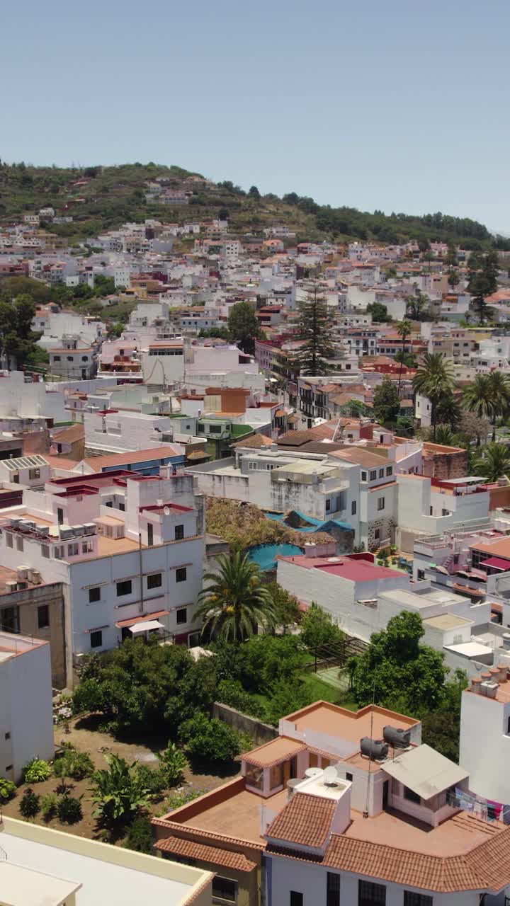 Inquadratura aerea verticale in allontanamento che mostra il colorato centro storico di Teror a Gran Canaria, evidenziando strade e architettura storica.