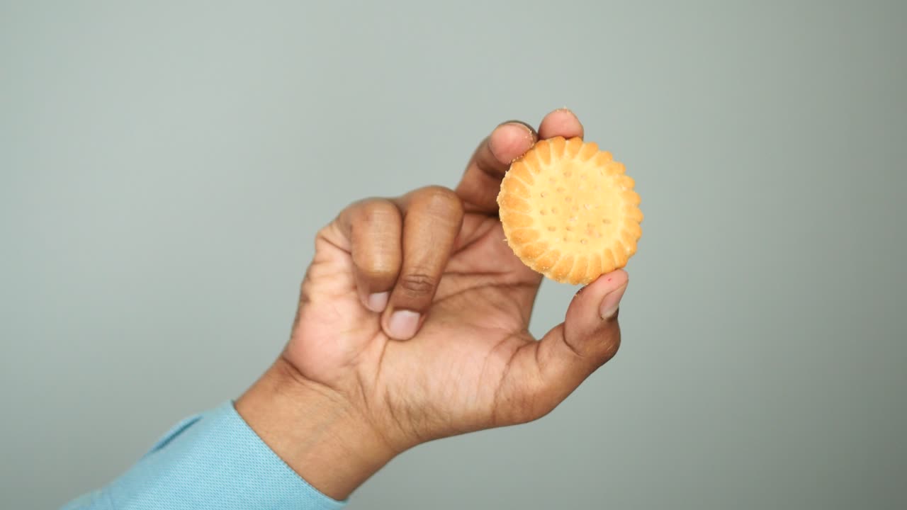 Hand holding a round cookie