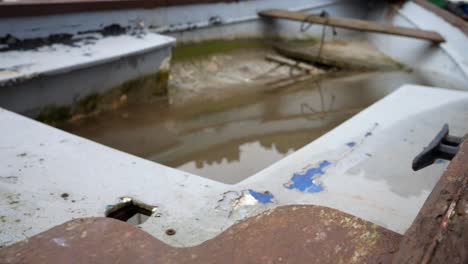 oxidado corroído viejo barco de pesca lleno de agua de tormenta cerrar dolly tiro izquierdo