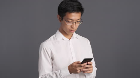 asian man using smartphone and celebrating.