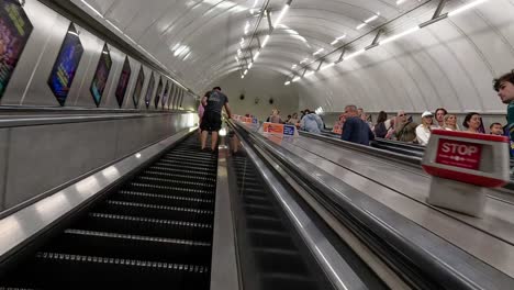 personas que usan escaleras mecánicas en la estación de londres