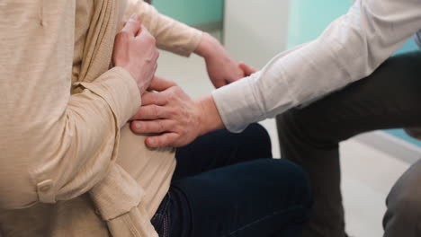 la cámara se enfoca en el esposo tomando de la mano a su esposa embarazada y tocándole el vientre en una consulta médica