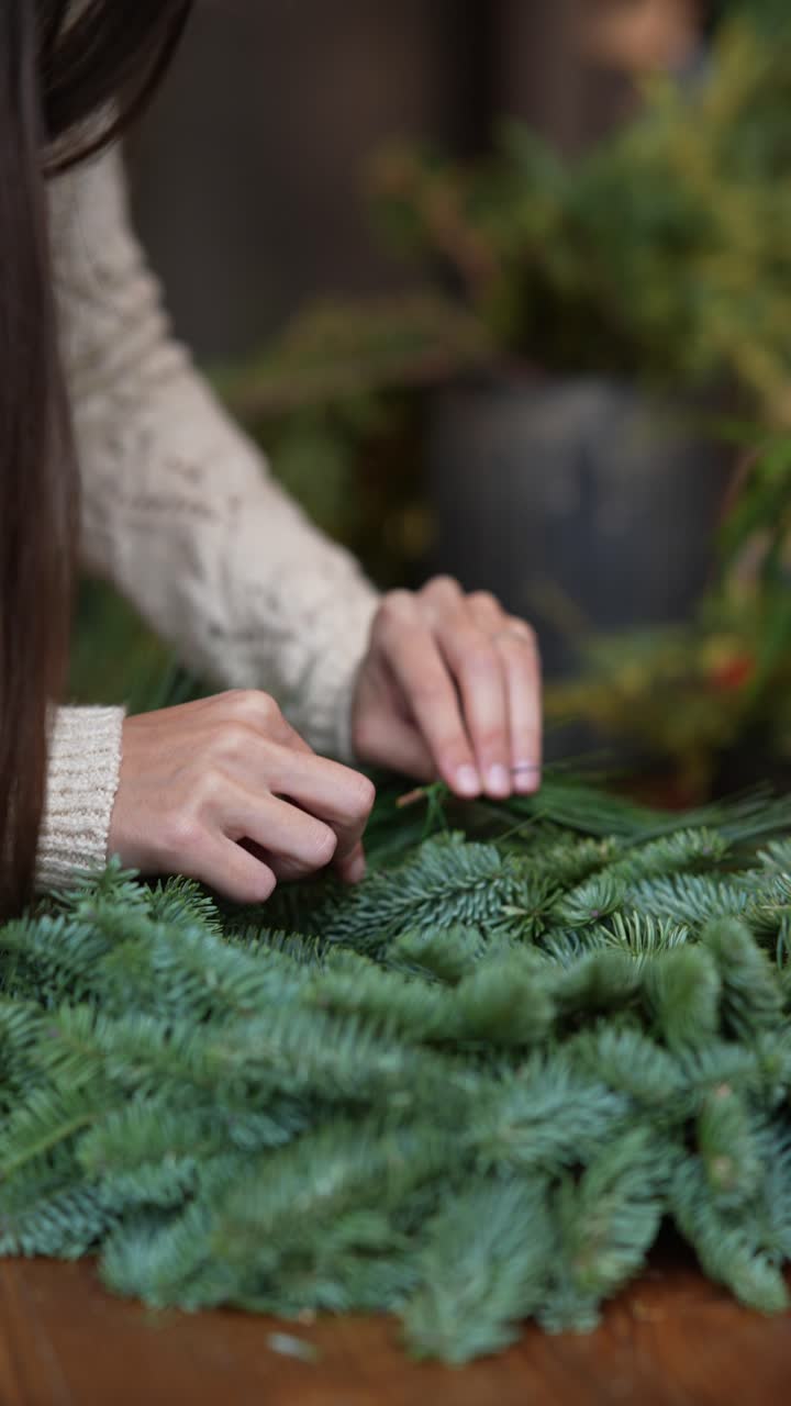 una mujer haciendo una corona de navidad.