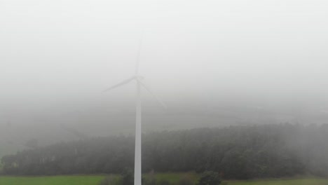 molino de viento en el rocío brumoso. energía eólica