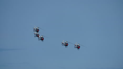 synchronized military helicopters performing precise aerial formation flight, demonstrating exceptional piloting skill against pristine blue sky backdrop