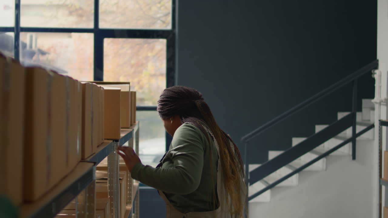 Woman in warehouse carrying boxes