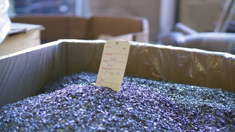 a box of tiny metal pieces with paper label sticking out