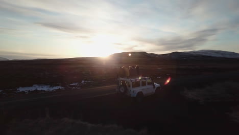 Gruppe-Junger-Reisender,-Die-Auf-Einem-Landrover-Sitzen-Und-Einen-Wunderschönen-Sonnenuntergang-Beobachten