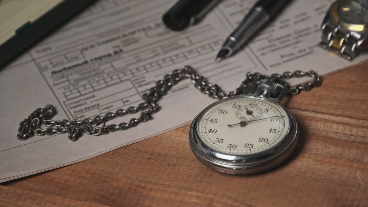 el cronómetro vintage se encuentra en un escritorio de madera con documentos viejos y cuenta segundos.