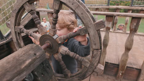 niño jugando con un timón de barco - imaginación jugando a hacer creer