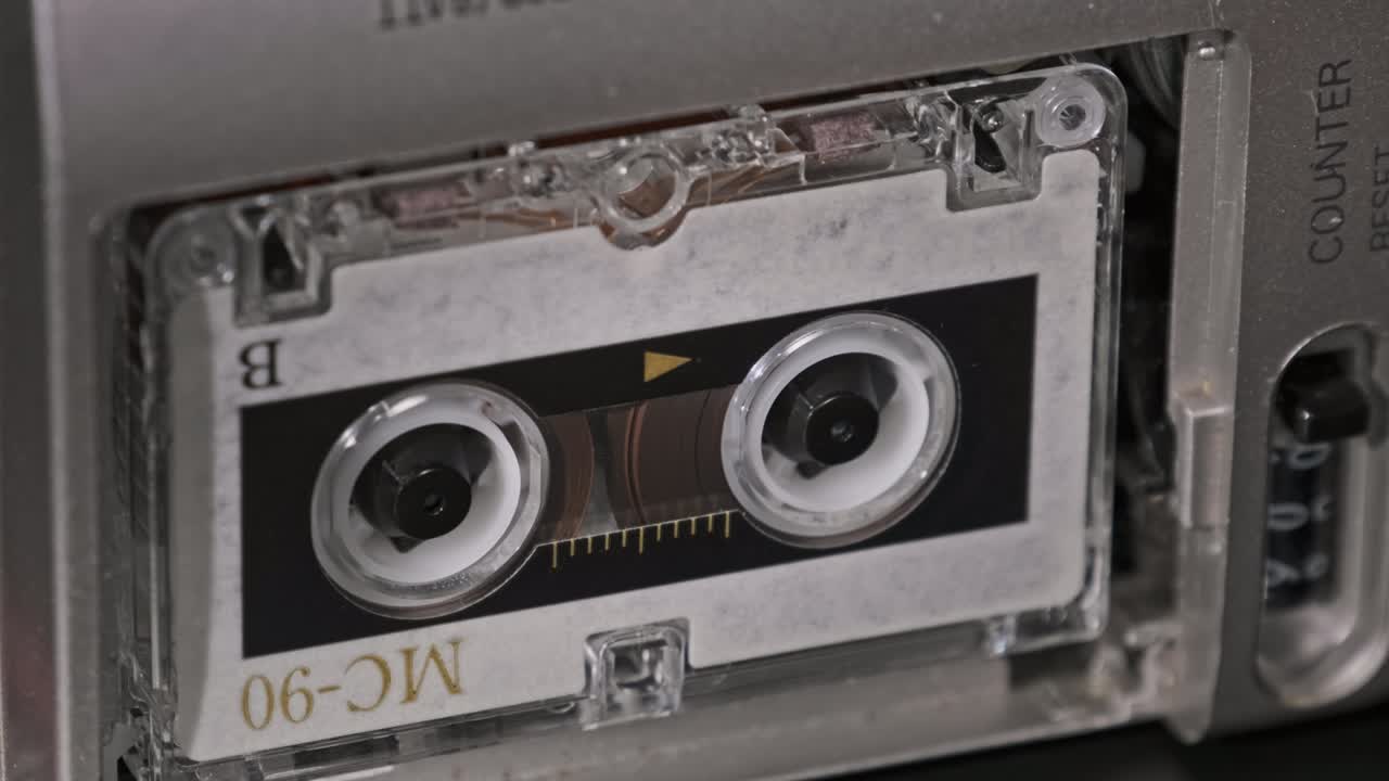 테이프 레코더에 있는 오디오 카세트가 재생되고 회전합니다.