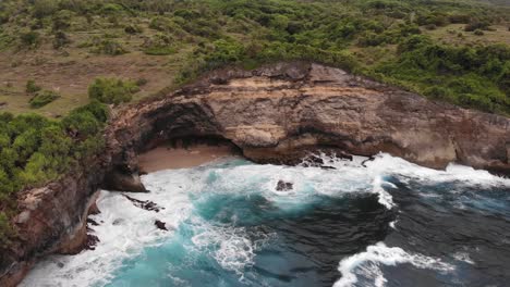 Aerial-Cinematic-shot-of-vibrant-beautiful-sunset-over-huge-cliffs-in-Uluwatu-Bali-with-deep-blue-crashing-waves-at-the-base-of-the-ocean-2