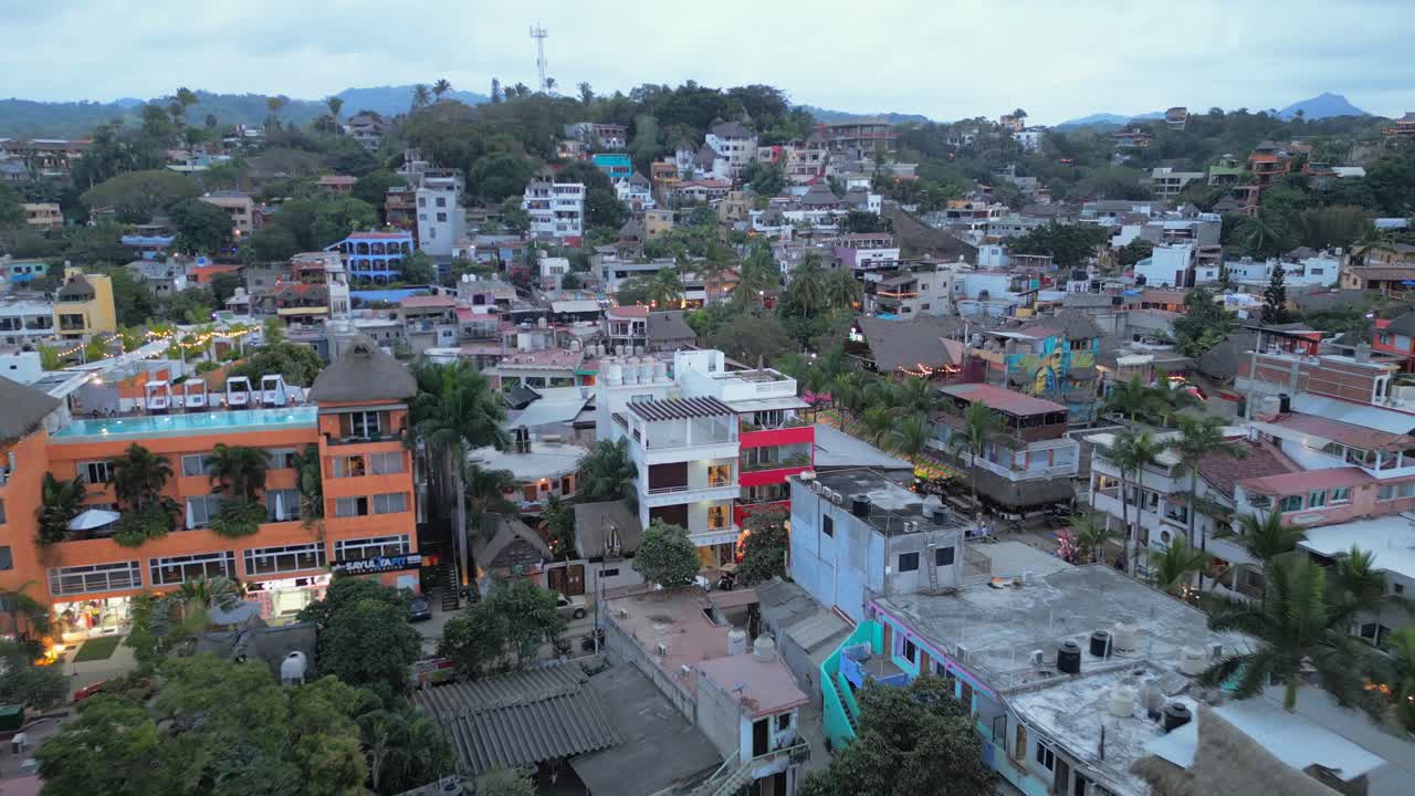 Un drone si allontana in volo mostrando l'estensione della città di Sayulita, Messico, e i colori vivaci degli edifici