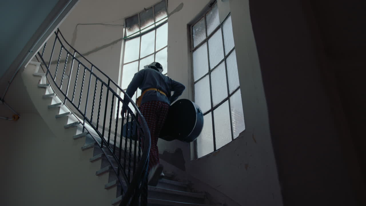 Man with Guitar Walking Upstairs in Old Apartment Building