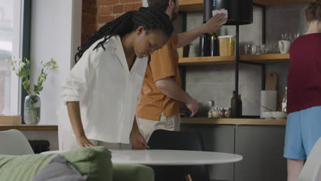 colegas de quarto limpando a cozinha de seu apartamento compartilhado